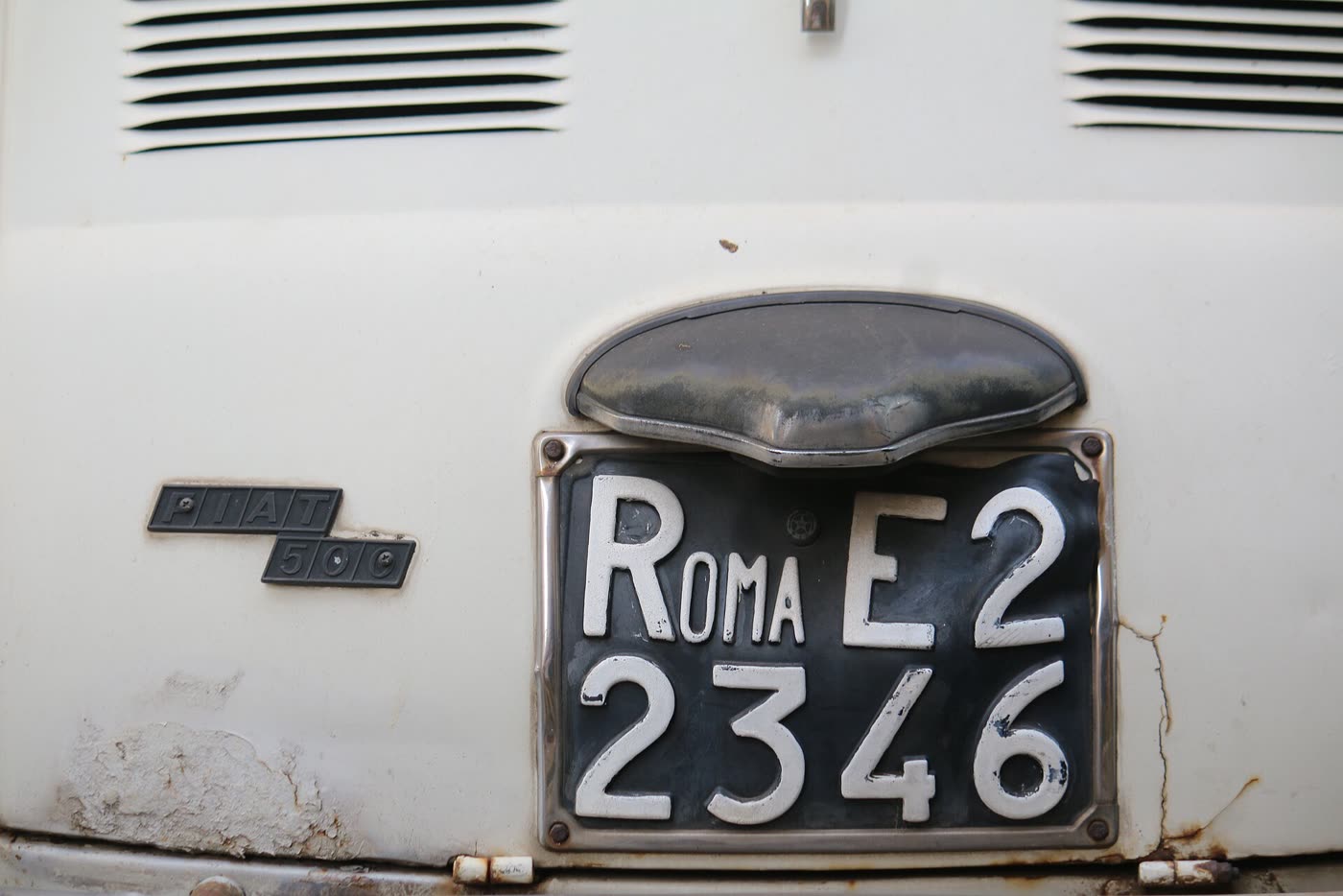 Fiat 500 bianca con la targa nera ROMA E2 2346